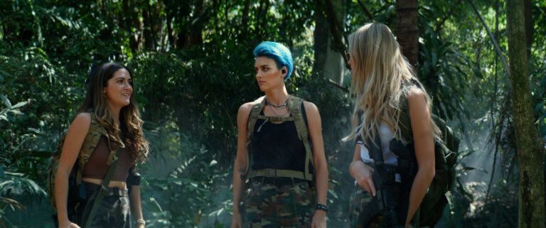 (L-R) Isabelle Fuhrman, Wallis Day and Sasha Luss in the jungle wearing camouflage.