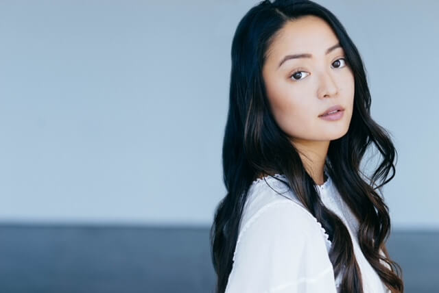 Actor Chelsea Zhang looking into the distance outside by the ocean.
