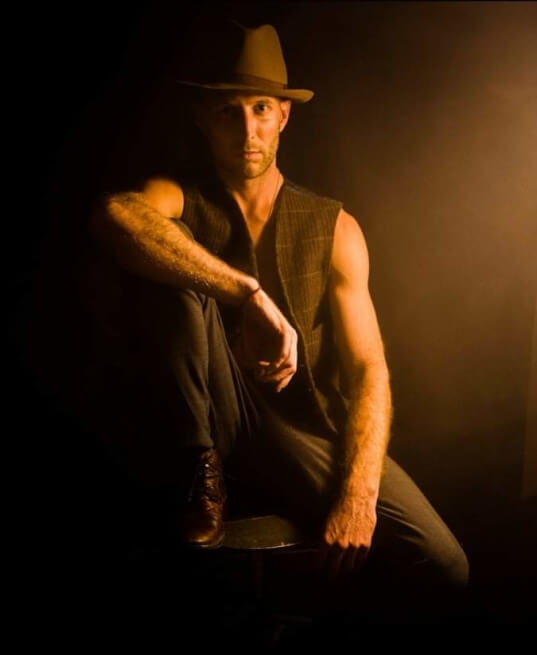 Actor Jon Michel Roberts posing in a theater gangster costume.