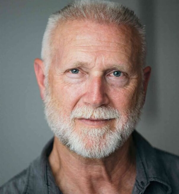 Actor Robert Fleet smiling in a gray shirt.