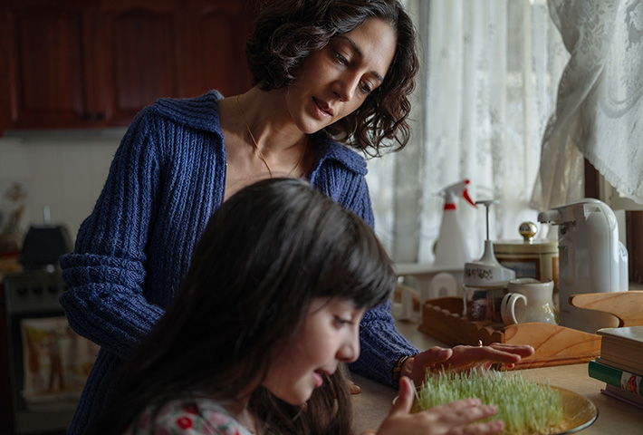 A mother and daughter cooking in the kitchen.