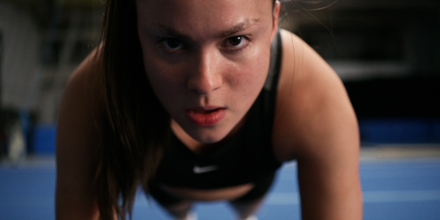 Devery Jacobs doing push ups and looking intense.