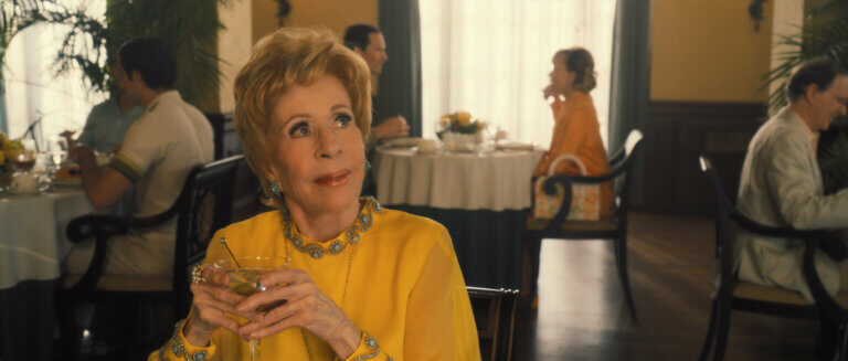 Carol Burnett in a yellow shirt at a restaurant.