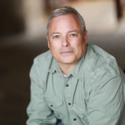 Paul Schnee in a green shirt smiling.