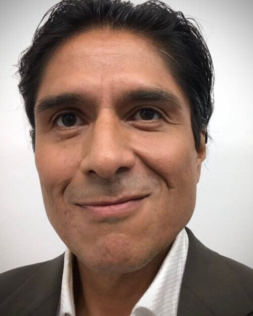 Ernesto García-Orduña smiling in a suit.