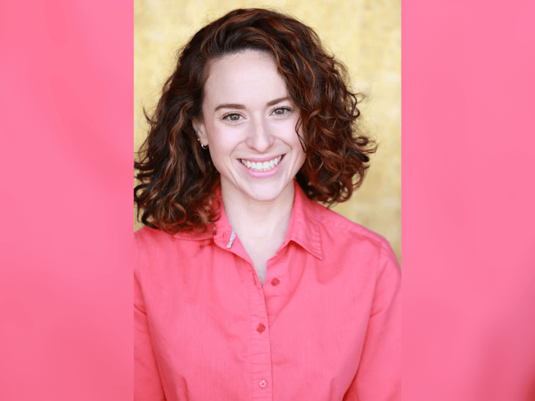 Audrey Del Prete smiling in a pink shirt.