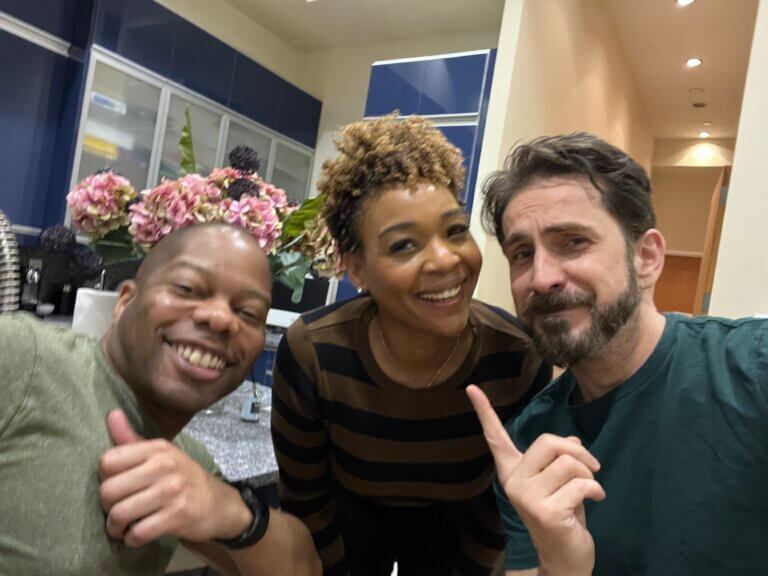Nathan Reid in a room with friends smiling.