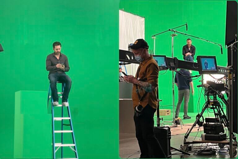 Natahn Reid and Ryan Reynolds sitting on ladders in front of a green screen. during a commercial shoot