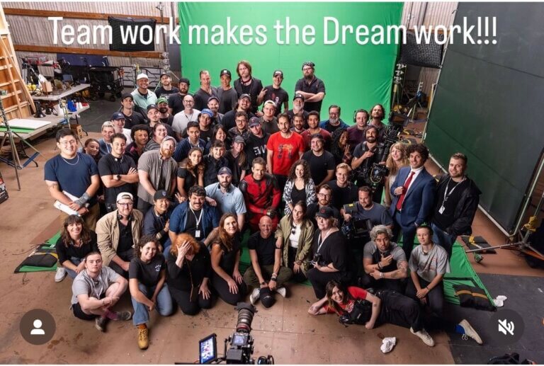 Nathan Reid, Ryan Reynolds and the Maximum Effort production team smiling on set.