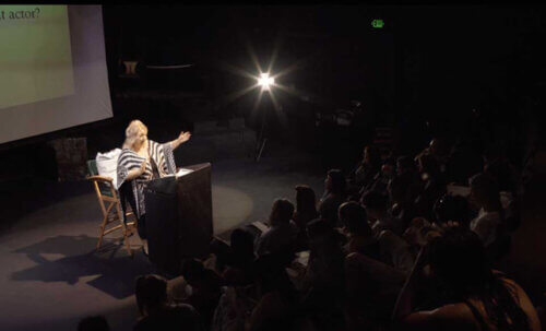 Michelle Danner teaching a packed acting class on stage.