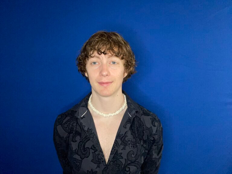 Morgan Seiter smiling in front of a blue screen.