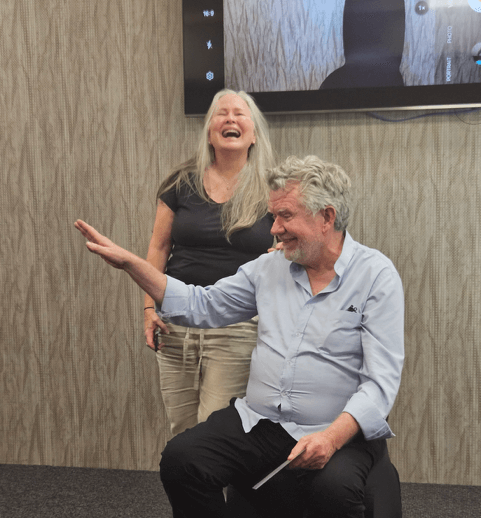 Casting director Gregory Apps and Robyn Gibbes conducting an acting seminar in a theater, with Gibbes laughing at a joke.