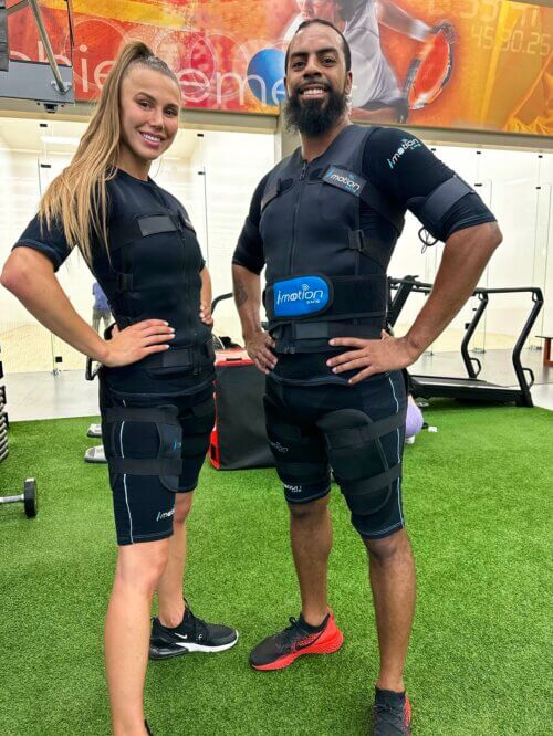 Matthew Horn and a personal trainer posing in workout gear inside a crossfit gym.