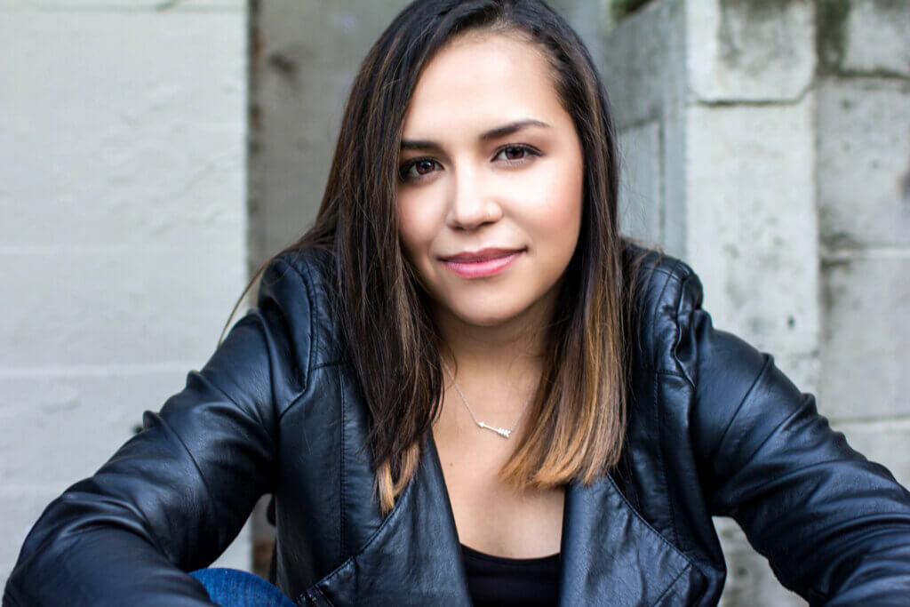 Rachel Espendez smiling in a black leather jacket with her hair straightened.