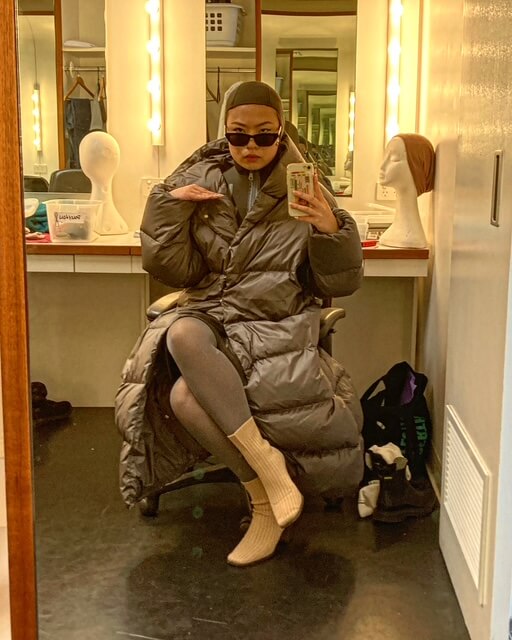 Grace Chow in a makeup chair taking a selfie in an OIL Costume