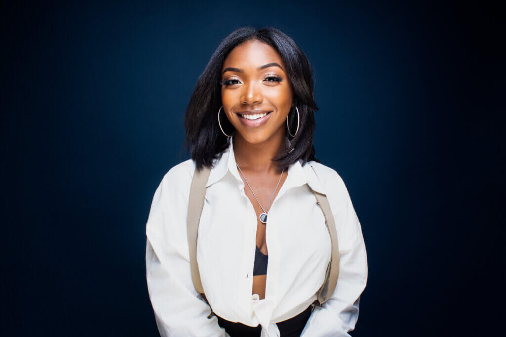 Casting Networks Discover Adult Talent Winner Jade Rushing smiling in a white shirt with suspenders.