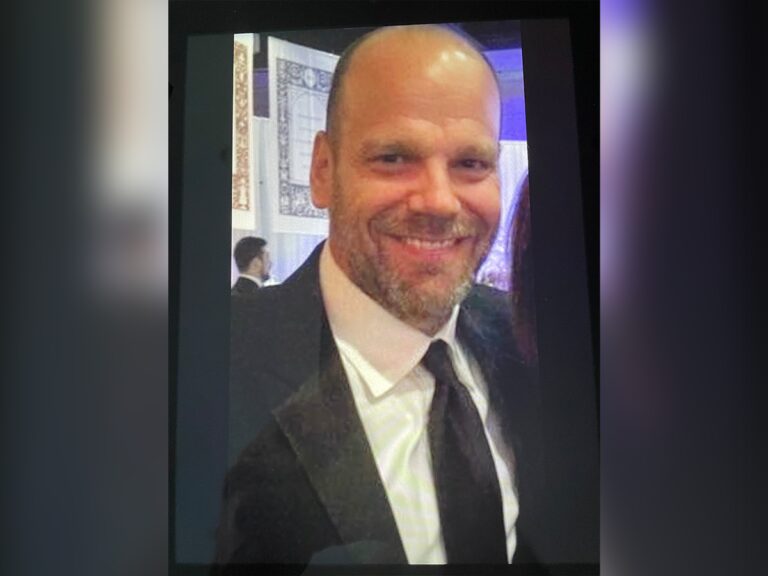 Casting director Tim Payne smiling in a black suit at an event.